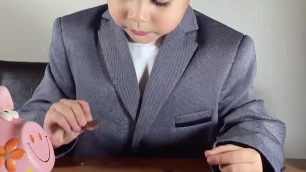 Söt Pojke Kostym Som Räknar Mynt Finansieringsutbildning Sparkoncept För Barn — Stockvideo