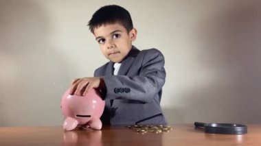 Çocuk, takım elbiseli çocuk bozuk domuz kumbarasını tamir ediyor. Ekonomik durgunluk, durgunluk ve olumsuz sonuçlar birbirini tutuyor. Yüksek kalite 4k görüntü