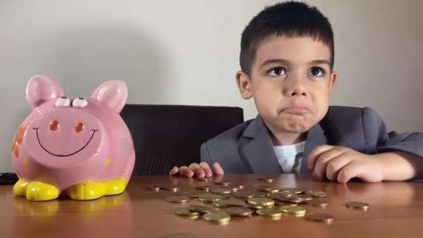 Roztomilé Dítě Chlapec Obleku Smutným Výrazem Tváři Dívající Prasátko Mince — Stock video