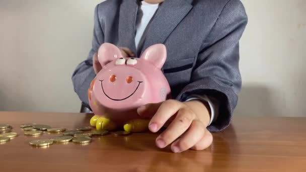 焦点を当てた就学前の子供 コインを数えるスーツの少年 投資の概念と子供の貯蓄 高品質4K映像 — ストック動画