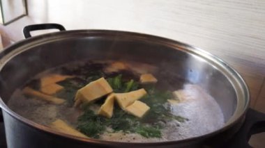 Çorba pişiriyorum. Şef yavaş çekimde haşlanmış suya sebze atıyor. Yüksek kalite 4k görüntü