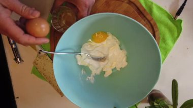 Yumurta kırmak ve kremalı tabağa koymak. Yukarıdan, yavaş çekimde. Yüksek kalite 4k görüntü