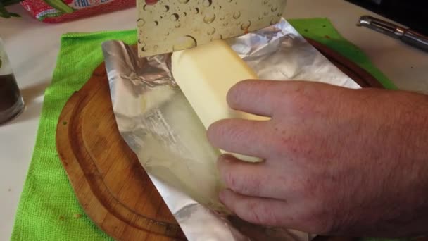 用厨房的切菜刀在木制切菜板上切黄油 用男性的手慢慢地把黄油切碎 高质量的4K镜头 — 图库视频影像
