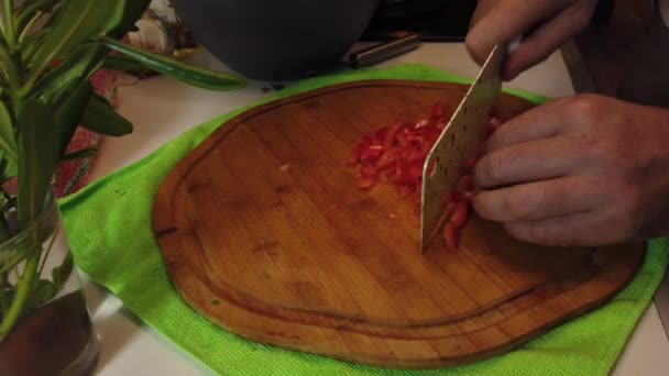 Mężczyzna Trzyma Kroi Czerwoną Paprykę Plasterki Przy Użyciu Tasaka Kuchennego — Wideo stockowe