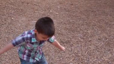 Cute toddler throws dry fallen leaves above him with excitement. Oudoors fall activites. Slow motion. High quality FullHD footage