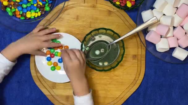学龄前儿童试用彩色糖果 去除水中的颜色 高质量的4K镜头 — 图库视频影像