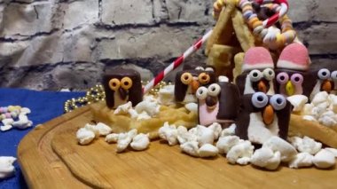 Yaratıcı gıda dekorasyonu. Tatlı marshmallow penguenleri ve waffle evi. Tatlılar ve tatlılar. Yüksek kalite 4k görüntü