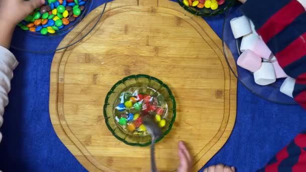 カラフルなキャンディーを試している就学前の子供たち 水の中の色を削除します 高品質4K映像 — ストック動画