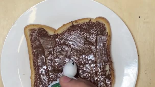 Sahne Über Toast Mit Schokoladenaufstrich Geben Süßes Frühstück Hochwertiges Filmmaterial — Stockvideo