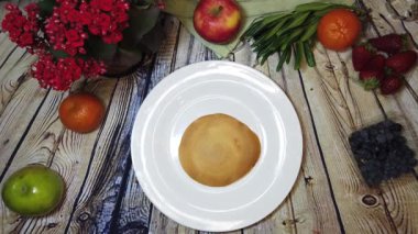 Tatlı domuz gözlemesi, mini gözlemeler domuz karakterini beyaz bir tabakta, ahşap bir masada meyveli bir araya getiriyor. Yüksek kalite 4k görüntü