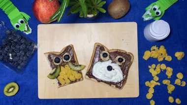 Yaratıcı çocuk kahvaltısı. Baykuş ve ayı şeklinde süslenmiş çikolata doğrama tahtasının üzerinde. Yüksek kalite fotoğraf