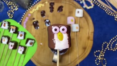 Yaratıcı gıda dekorasyonu. Tatlı penguen, tatlı ve tatlı dilimleme tahtasının üzerinden kayıyor. Yüksek kalite 4k görüntü