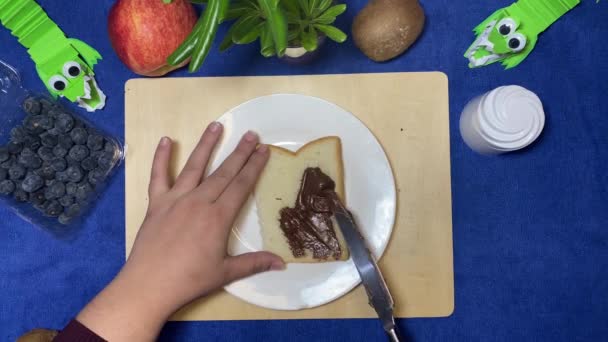 お母さんは子供の朝食を作る パンにチョコレートを広げる女性の手 高品質の写真 — ストック動画