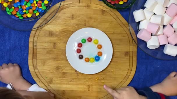 Παιδικά Πειράματα Πολύχρωμες Καραμέλες Στο Λευκό Πιάτο Λιώνουν Ένα Ουράνιο — Αρχείο Βίντεο