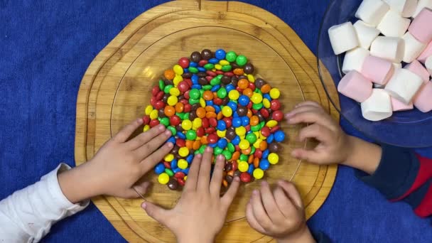 Ανυπόμονα Παιδιά Που Παίζουν Πολύχρωμες Καραμέλες Τοποθετημένες Ξύλινη Σανίδα Επίπεδη — Αρχείο Βίντεο