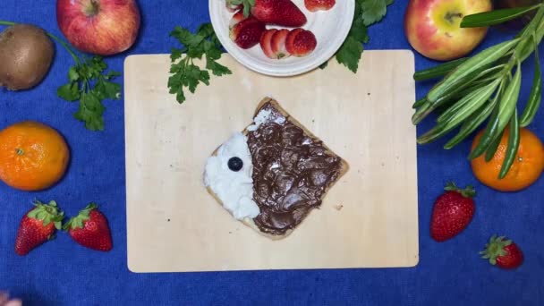 創造的な子供の朝食 イチゴとブルーベリーで広がる魚の形をしたチョコレートパン 動くな 高品質4K映像 — ストック動画