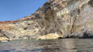 Comino, Malta, Ekim 2023 - Kristal Göl, tekne turu, kireçtaşı mağaraları ve kristal berrak turkuaz sular. Yüksek kalite 4k görüntü
