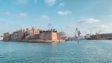 Birgu, Malta, 23.10.2023 - Zaman Kalesi St. Angelo, Birgu Denizcisi, yolcu gemisi ve yanaşma vinçleri ile. Yüksek kalite 4k görüntü