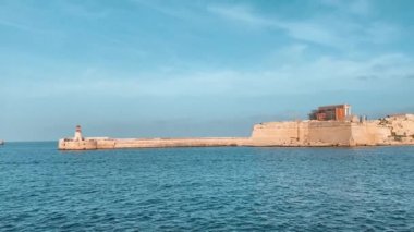Ricasoli East Breakwater, Malta. Körfezin diğer tarafından Valetta 'ya, sonunda kırmızı bir deniz feneri olan dalgakıran. Yüksek kalite 4k görüntü