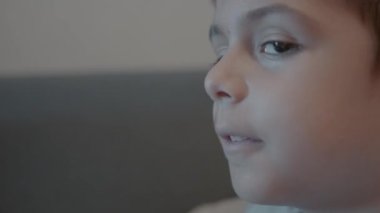 Yaramaz yüz ifadesi olan çocuğun profil görüntüsü, kameraya doğru dönüyor. Ağır çekim. Yüksek kalite 4k görüntü