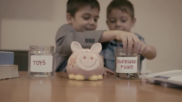 金融教育 儿童储蓄 两个兄弟在罐子的名字 应急基金或脏话罐的问题上意见不一 慢动作 高质量的4K镜头 — 图库视频影像