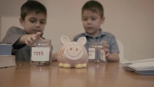 Финансовое Образование Сбережения Детей Два Мальчика Сортируют Монеты Между Банкой — стоковое видео