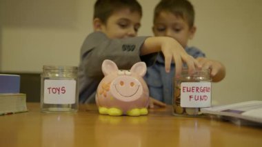 Finansal eğitim. Çocuk tasarrufu. Kavanoz ismi, acil durum fonu ya da küfür kavanozu konusunda anlaşamayan iki kardeş. Ağır çekim. Yüksek kalite 4k görüntü