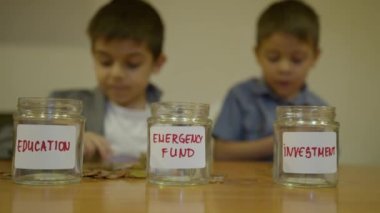 Finansal eğitim ve çocuklar için tasarruf. Takım elbiseli çocuk eğitim için kavanoza para koyuyor. Bütçe belirleme. Yüksek kalite 4k görüntü