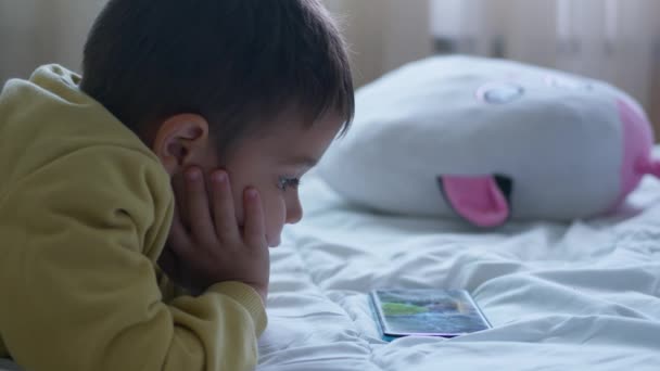 Roztomilé Předškolní Dítě Ležící Posteli Dívající Kreslené Seriály Telefonu Otáčí — Stock video