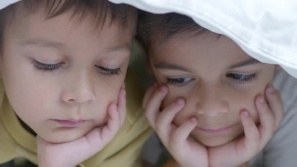 Dwoje Dzieci Oglądających Kreskówki Łóżku Pokryte Kołdrą Chłodny Zimowy Dzień — Wideo stockowe