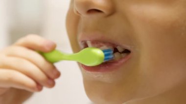 Diş hijyeni. Çocuk banyoda dişlerini fırçalıyor. Kapatın. Yüksek kalite 4k görüntü