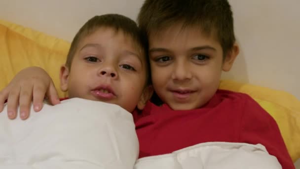 ベッドで抱き合う愛らしい兄弟姉妹 ベッドにいる兄弟たち 幸せな家族の愛と喜び 高品質の4K映像 — ストック動画
