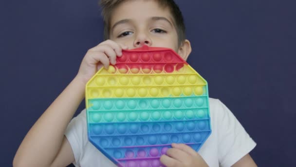 Симпатичный Мальчик Используя Красочные Антистрессовые Сенсорные Игрушки Fidget Толкать Поп — стоковое видео