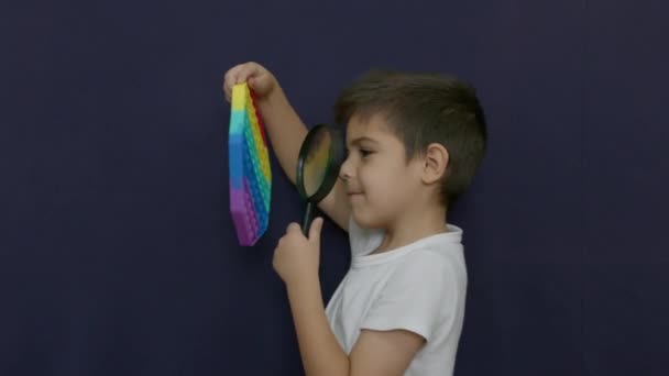 Biały Chłopiec Używający Szkła Powiększającego Patrzenia Antystresową Zabawkę Wysokiej Jakości — Wideo stockowe