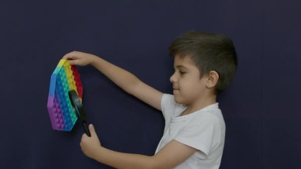 Blanke Jongen Die Een Vergrootglas Gebruikt Naar Pop Antistress Speelgoed — Stockvideo