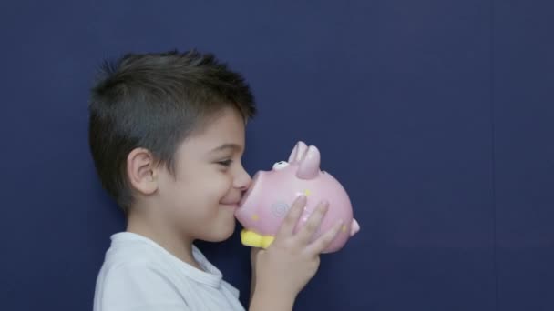 Концепція Заощадження Дітей Кавказький Хлопчик Грає Своїм Скарбничкою Кумедними Виразами — стокове відео
