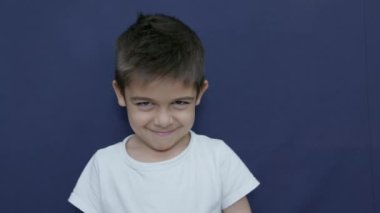 Nefret dolu bir jest. Parmağını yere koyan bir çocuk. Anlaşmazlık. Mavi üzerine kopyalama alanı ile izole edilmiş. Ağır çekim. Yüksek kalite 4k görüntü