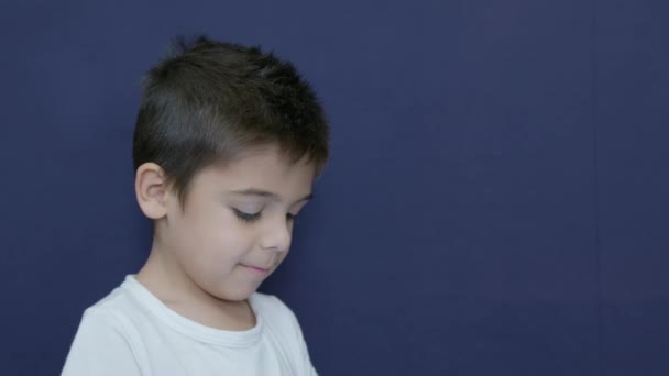 白人儿童不同意 有趣的愤怒的表情 被蓝色背景隔离 动作缓慢 高质量的4K镜头 — 图库视频影像