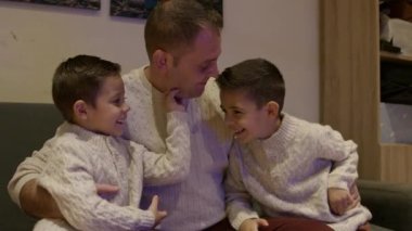 Baba ve oğulları kanepede oynaşıyorlar. Kaliteli bir aile zamanı. Yüksek kalite 4k görüntü