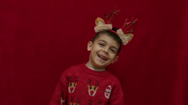 可爱的孩子 长着驯鹿耳朵和角 在红色蓬松的背景上跳舞 慢动作 高质量的4K镜头 — 图库视频影像