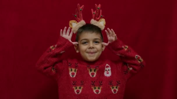 Милий Малюк Робить Смішні Вирази Обличчя Оленячими Вухами Рогами Різдвяному — стокове відео