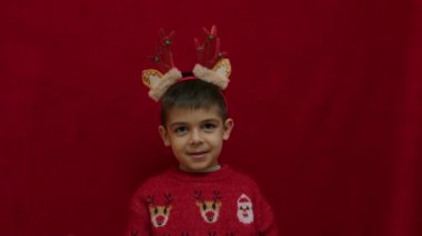 Hiçbir fikrim yok. Noel 'de çirkin süveter giyen, ren geyiği kulaklı, boynuzlu, yardıma muhtaç bir çocuğun el hareketi. Hiçbir fikrim yok, emin değilim. Yüksek kalite 4k görüntü
