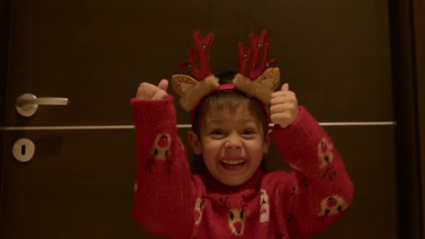 Пальцы Вверх Возбужденный Счастливый Ребенок Рождественском Свитере Оленьих Рогах Волнением — стоковое видео