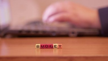 Finansal konsept. Bilgisayarda boncuklarla çalışan kişinin elleri kelime bütçesi oluşturuyor. Yüksek kalite 4k görüntü