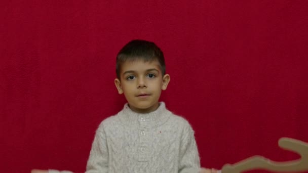 Χαριτωμένο Παιδί Αμφισβητεί Κάτι Κρατώντας Ερωτηματικό Απομονωμένο Στο Κόκκινο Χώρο — Αρχείο Βίντεο