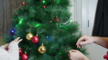 Baba ve oğulları Noel ağacı süslüyorlar. Elf şapkaları. Mutlu noeller. Yüksek kalite 4k görüntü