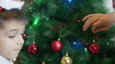 Baba oğul Noel ağacı süslüyorlar. Mutlu aile ve tatil ruhu. Yüksek kalite 4k görüntü