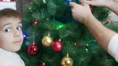 Baba oğul Noel ağacı süslüyorlar. Mutlu aile ve tatil ruhu. Yüksek kalite 4k görüntü