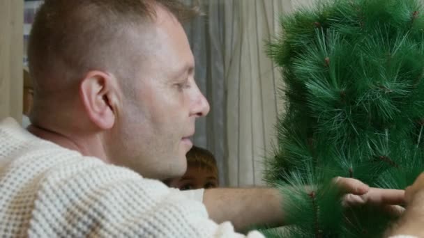 父と息子が人工的なクリスマスツリーを一緒に組み立てます クリスマス休日と質の高い家族の時間 高品質の4K映像 — ストック動画