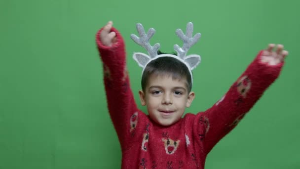 Sød Førskoledreng Med Rensdyrgevir Juletrøje Der Viser Tommelfingre Isoleret Grøn – Stock-video